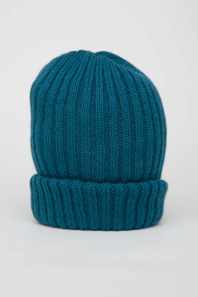 Close up of a beanie hat in a rich teal blue.
