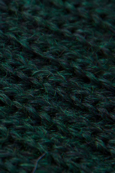 rolled up dark green knitted scarf