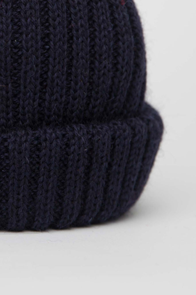 close up of our Navy Dobbo, a short knitted beanie