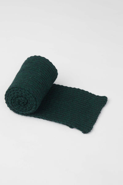 rolled up dark green knitted scarf