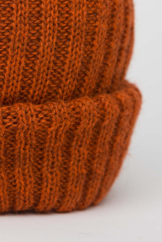 close up of burnt orange knitted beanie